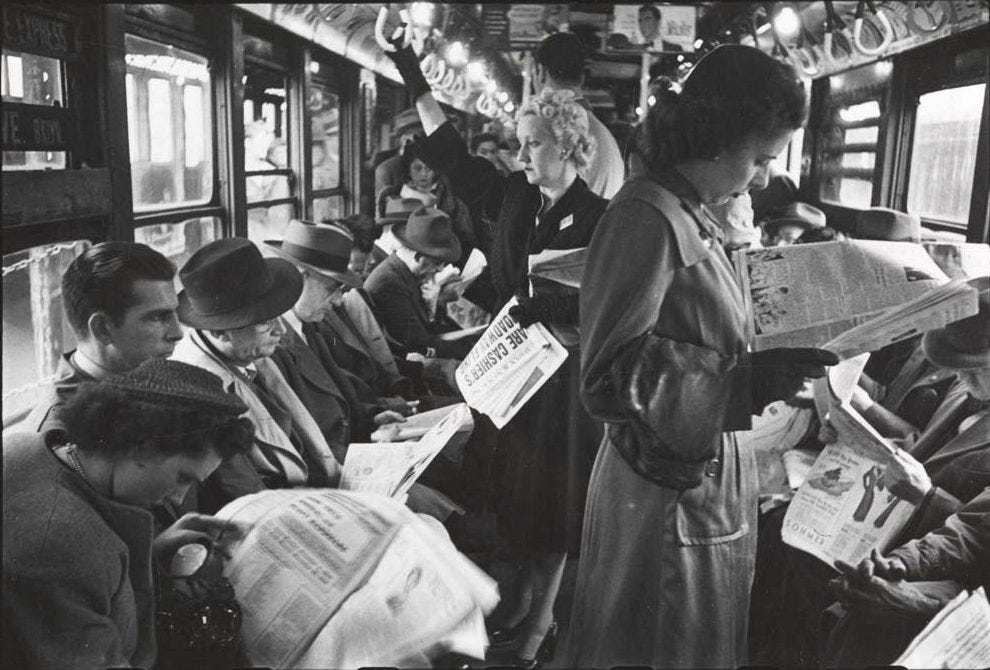 Passageiros lendo jornal num vagão de trem, década de 1940